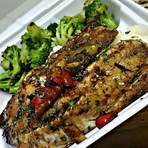 Cajun-style fish fillets with red and green peppers, served with mashed potatoes and broccoli.